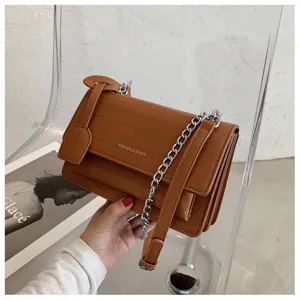 Brown croc pattern crossbody bag featuring chic silver chain strap and flap closure.