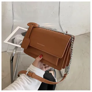 Close-up shot of brown crocodile texture shoulder bag featuring chic metal chain strap.
