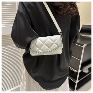 Detail shot of a trendy white quilted shoulder bag featuring a stylish chain strap.