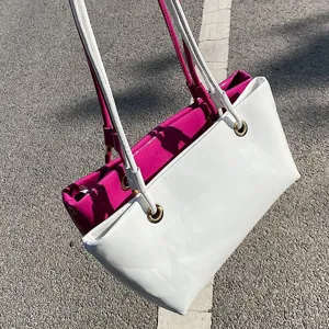 Glossy patent leather tote bag, stylish dual-color shoulder bag for women commuting daily.