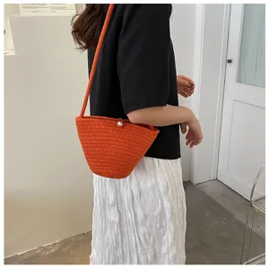 Stylish orange woven bucket bag for women, cute autumn shoulder bag with pearl closure.