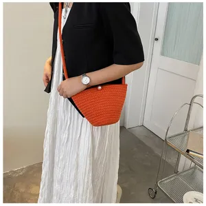 Detailed lifestyle shot showcasing the orange woven bucket bag worn across the body.