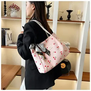 Sac cabas épaule en velours côtelé rose avec imprimé cerise, foulard en soie et poignée tressée.