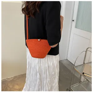 Detailed view of an orange woven bucket bag worn by a model, showcasing its daily styling and design.