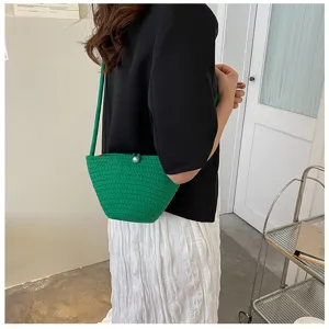 Green woven bucket bag detail view, stylish shoulder bag with pearl decor for women everyday use.
