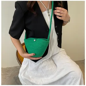 Green woven bucket bag with pearl closure and slim strap for daily stylish casual outfits.