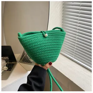 Green woven bucket bag with pearl button, stylish casual crossbody bag for daily use.