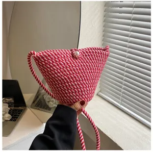 Red and white woven bucket bag detail shot, stylish pearl button closure crossbody bag.