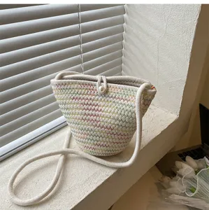 Detailed view of fashionable woven bucket bag with colorful knit pattern and pearl button.