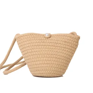 Woven small bucket bag, stylish fashion crossbody phone bag with cute pearl closure detail view.