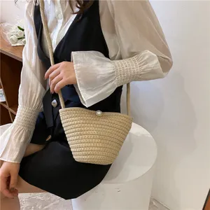 Chic straw woven bucket bag featuring pearl closure, stylish casual crossbody small bag for daily wear.