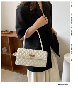 Elegant white quilted underarm bag with gold lock for women, stylish shoulder baguette bag.