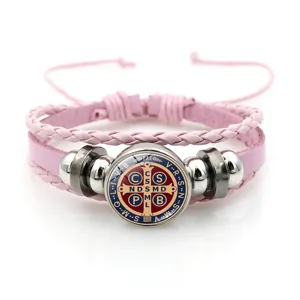 Pink braided leather bracelet with metal beads and Saint Benedict medal pendant accessory.