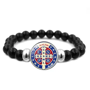Bracelet en perles avec médaille de Saint-Benoît et pendentif en verre en détail.