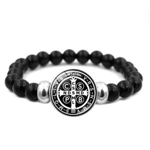 Bracelet de perles noires avec une medaille ronde de Saint-Benoit et croix religieuse.