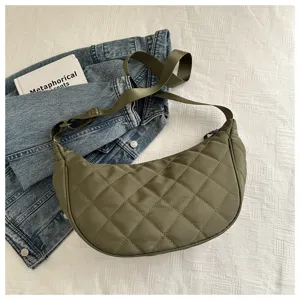 Green nylon quilted crescent crossbody bag detail showcasing texture and adjustable strap.