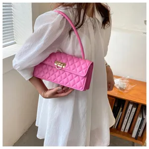 Detailed view of pink quilted shoulder bag with gold lock, stylish baguette bag design.
