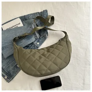 Detail view of a stylish quilted nylon crescent shoulder bag in army green with adjustable strap.