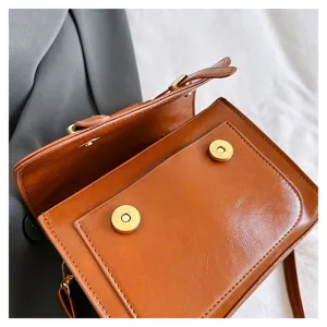 Gros plan détaillé du sac bandoulière en cuir vintage marron, montrant de beaux détails.