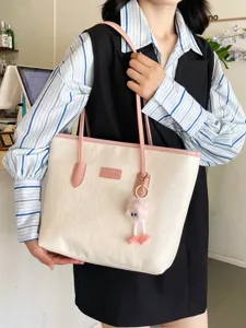 Stylish women large tote bag with embossed design pink straps and cute plush charm.