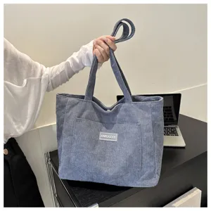 Grey corduroy tote bag detail showing large capacity, soft texture and sturdy shoulder strap.