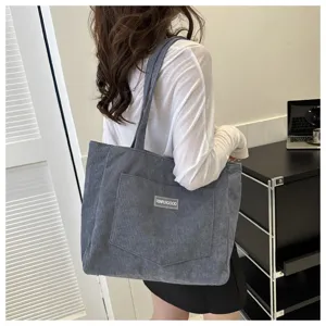Detail shot of women's grey corduroy tote shoulder bag, stylish casual everyday handbag.