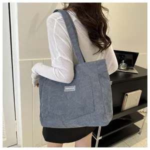 Corduroy shoulder tote bag detail showing large capacity, soft fabric and front pocket design.
