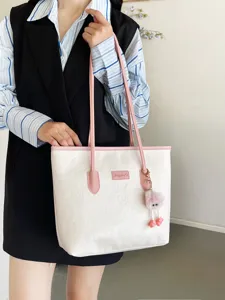 Chic white tote bag with pink straps and debossed details, perfect for daily commuting.