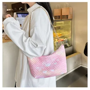 Detail view of a trendy pink gradient quilted shoulder bag with a stylish gold chain.