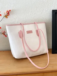 Detailed view of white tote bag with pink straps and embossed texture, stylish design.