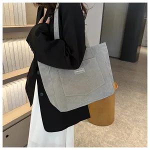 Detail view of stylish grey corduroy tote bag, casual large capacity shoulder handbag.