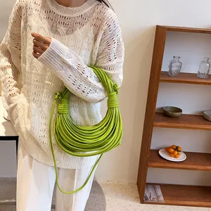 Close-up detail of the unique green knotted noodle handbag showcasing intricate rope texture design.