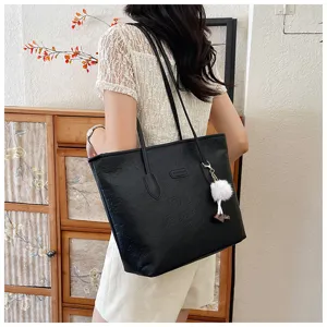 Large capacity black tote bag for women, stylish embossed shoulder bag for daily commute.