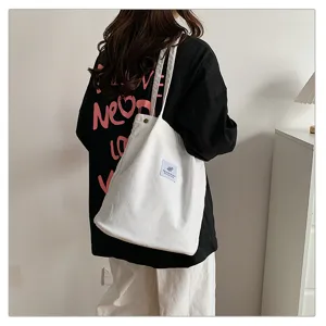Detailed view of the white corduroy shoulder tote bag, casual large capacity bucket design.