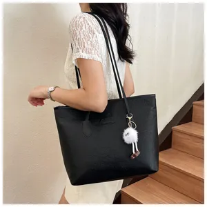 Stylish black PU leather tote bag for women with embossed pattern and cute plush pendant.