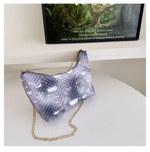 Detail view of quilted nylon shoulder bag with cute butterfly and rainbow pattern and chain strap.