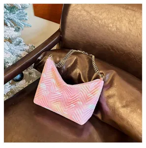 Pink quilted underarm shoulder bag with chic gold chain strap, winter fashion design detail.