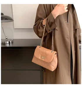 Elegant quilted shoulder bag with chain strap and chic turn-lock closure for daily commuting.