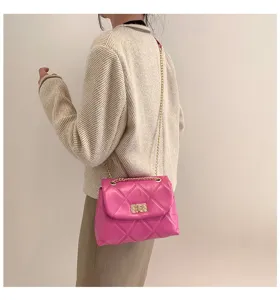 Detailed shot of pink quilted chain shoulder bag, elegant puffer crossbody bag with gold lock.