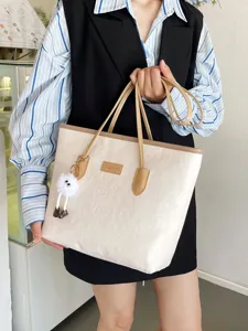 Detailed view of large capacity beige tote bag, premium debossed design, versatile commuter style.