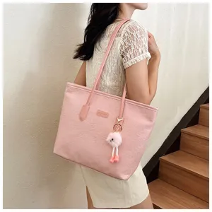 Pink large capacity tote bag women summer new embossed shoulder commuting bag with cute plush pendant.