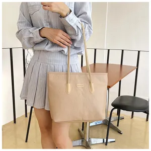 Beige large capacity tote bag for women, fashion embossed single-shoulder handbag for daily commute.
