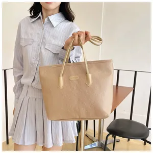 Beige large capacity embossed tote bag for women, stylish single shoulder commuter bag.