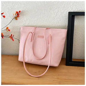 Pink tote bag detail, large capacity shoulder bag with embossed pattern and double handles.