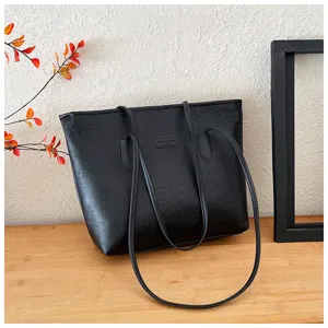 Black embossed leather tote bag for women, large capacity commuter shoulder bag detail.
