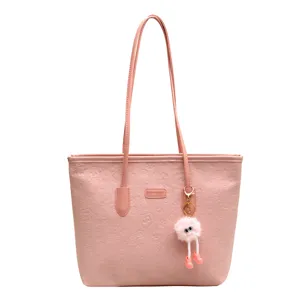 Stylish pink women shoulder tote bag with cute fuzzy charm and embossed patterns.