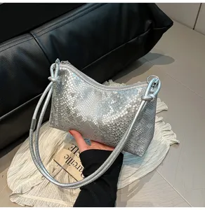 Silver metallic underarm shoulder bag with trendy knot straps, compact and stylish detail view.
