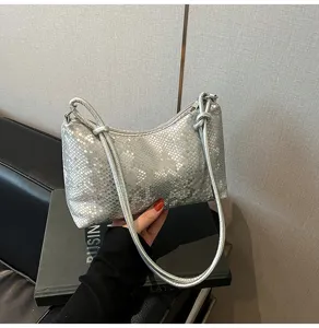 Silver metallic shoulder bag detail, stylish underarm handbag with chic strap design.