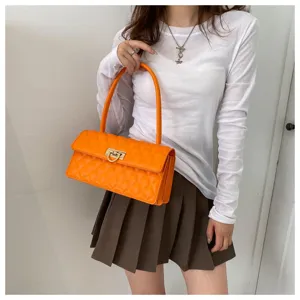 Orange quilted shoulder bag detail showcasing the metallic twist lock and handle design.