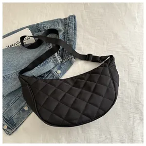 Black quilted nylon crescent shoulder bag detail view showing diamond stitching and strap.